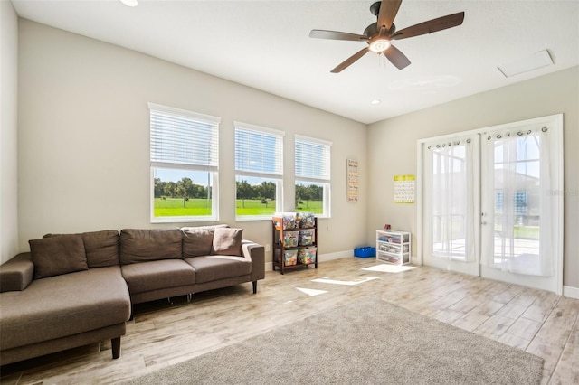 living room featuring light hardwood / wood-style floors, a healthy amount of sunlight, and ceiling fan