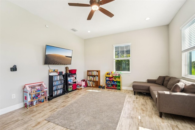 playroom with light hardwood / wood-style floors and ceiling fan