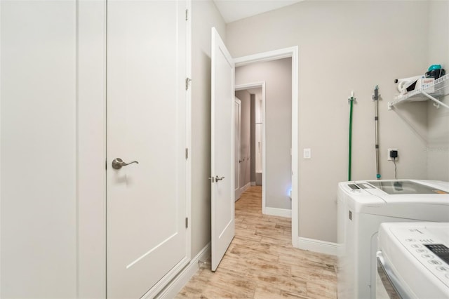 laundry room featuring light hardwood / wood-style flooring and washing machine and dryer