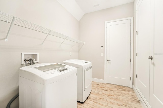 clothes washing area with light hardwood / wood-style flooring and independent washer and dryer