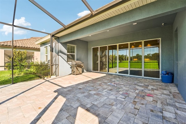 view of patio with area for grilling and a lanai