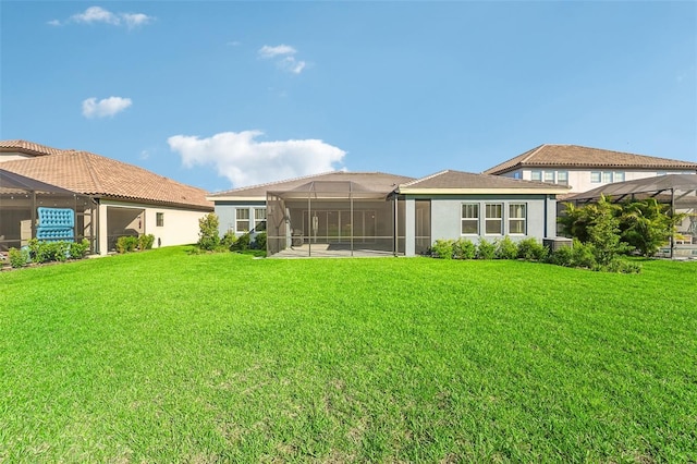 back of house with a lanai and a yard