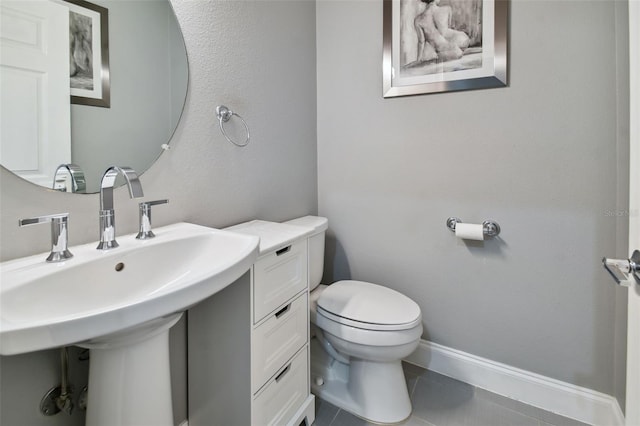 bathroom with toilet and tile patterned floors