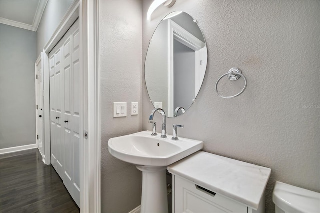 bathroom featuring toilet, crown molding, and hardwood / wood-style floors