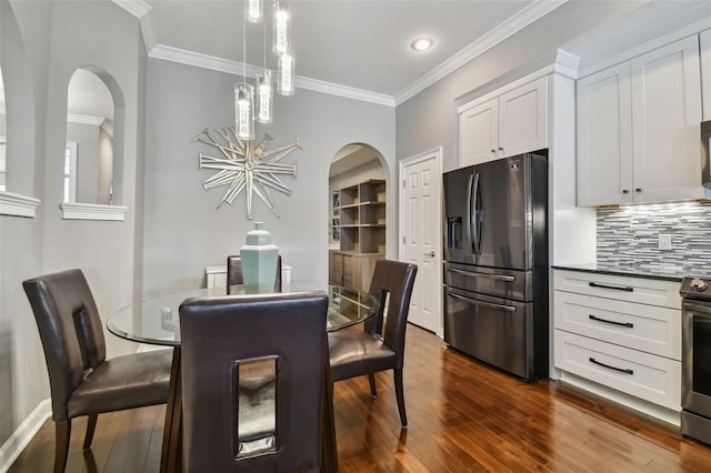 dining room with crown molding, a notable chandelier, and dark hardwood / wood-style flooring