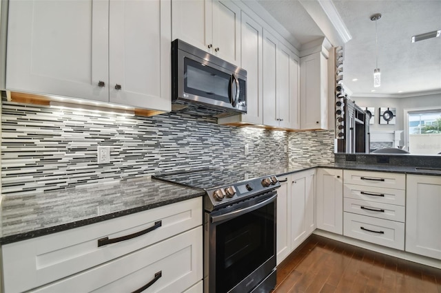 kitchen with stainless steel appliances, decorative light fixtures, dark hardwood / wood-style flooring, white cabinets, and tasteful backsplash