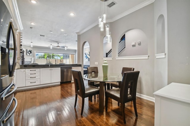 dining area with crown molding, sink, and dark wood-type flooring