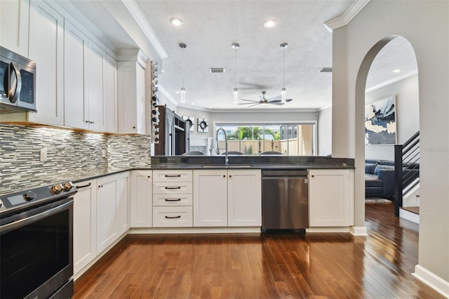 kitchen featuring appliances with stainless steel finishes, sink, pendant lighting, and dark hardwood / wood-style flooring