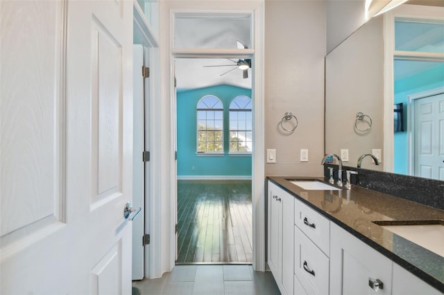 bathroom with vanity, hardwood / wood-style flooring, ceiling fan, and vaulted ceiling