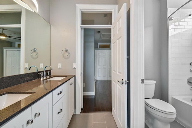 full bathroom featuring toilet, tiled shower / bath, vanity, and tile patterned flooring