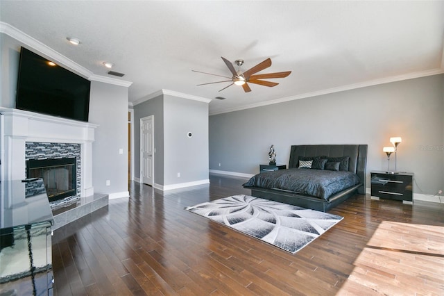 bedroom featuring crown molding, dark hardwood / wood-style floors, a tile fireplace, and ceiling fan