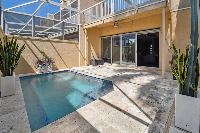 view of swimming pool with a patio, ceiling fan, and glass enclosure