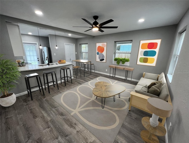 living room featuring ceiling fan, dark wood-type flooring, and sink