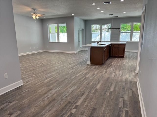 kitchen with sink, hanging light fixtures, ceiling fan, dark hardwood / wood-style floors, and a textured ceiling