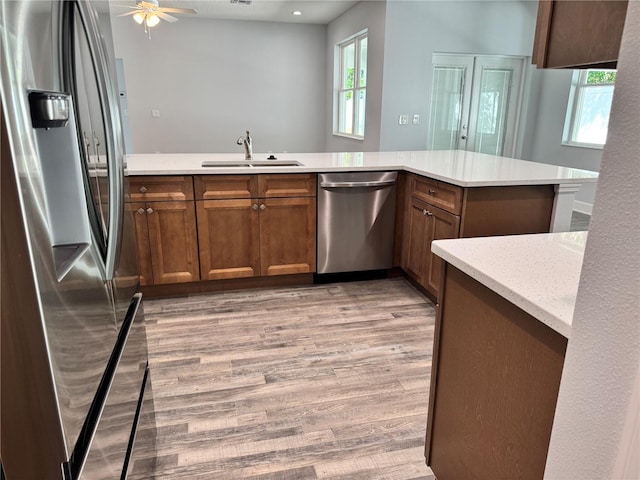 kitchen with a healthy amount of sunlight, kitchen peninsula, sink, and appliances with stainless steel finishes