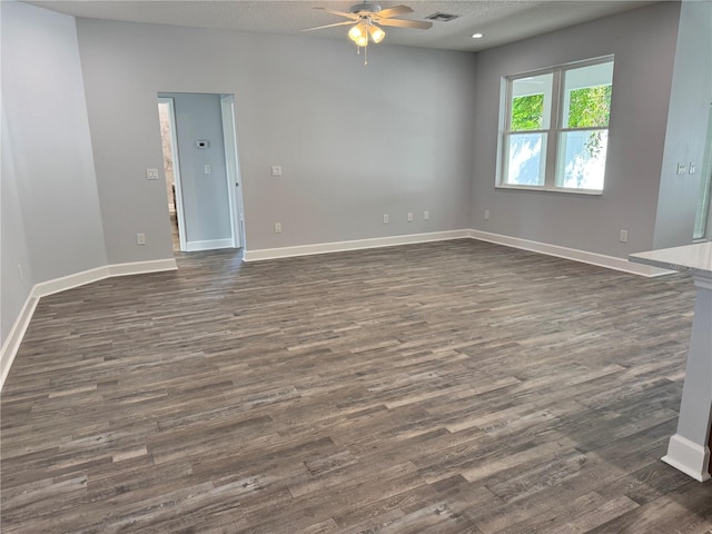 spare room featuring dark hardwood / wood-style floors, ceiling fan, and a textured ceiling