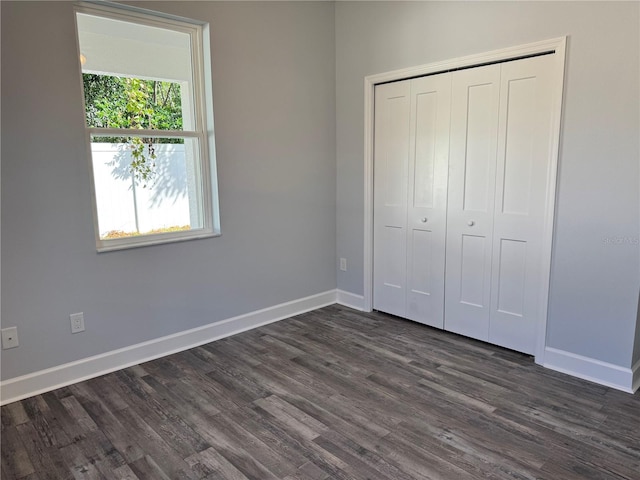 unfurnished bedroom featuring dark wood-type flooring and a closet