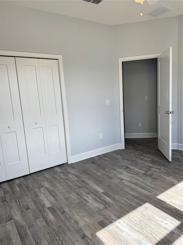 unfurnished bedroom featuring dark hardwood / wood-style flooring, a closet, and ceiling fan