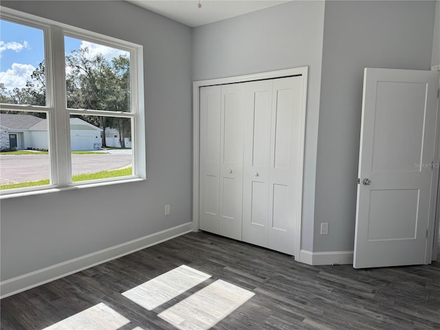 unfurnished bedroom featuring dark hardwood / wood-style flooring and a closet