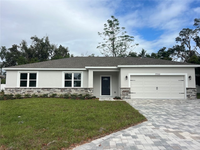 ranch-style home with a garage and a front lawn