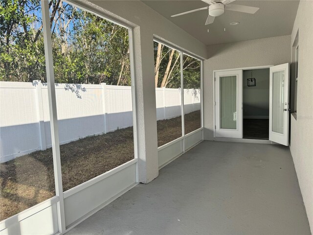 unfurnished sunroom with ceiling fan