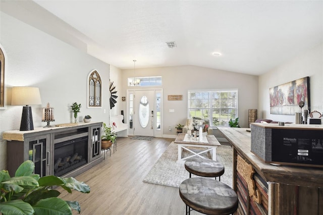 living room with vaulted ceiling and light hardwood / wood-style flooring