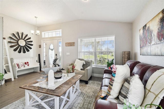 living room featuring hardwood / wood-style floors, lofted ceiling, and a chandelier