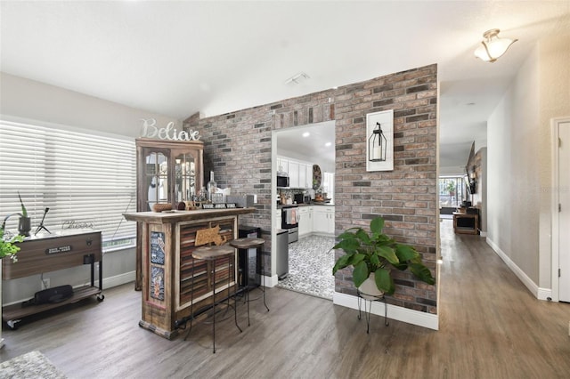 bar with white cabinets and wood-type flooring