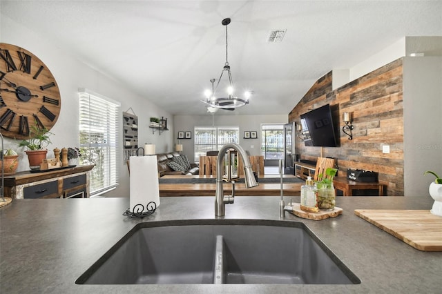 kitchen featuring sink, vaulted ceiling, and a notable chandelier