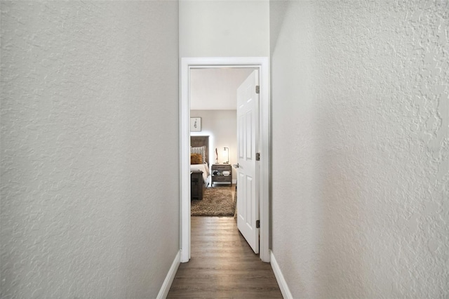 hallway with hardwood / wood-style flooring