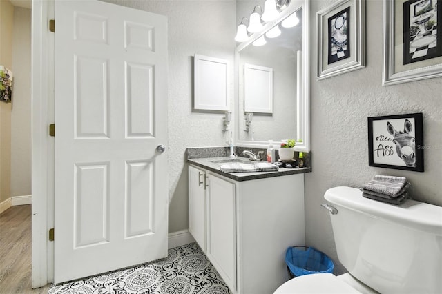 bathroom featuring toilet, hardwood / wood-style floors, and vanity