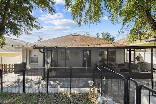 rear view of house featuring central AC unit