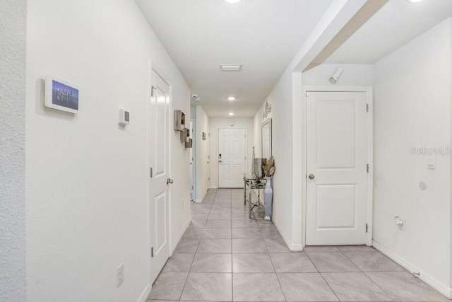 hall featuring light tile patterned floors