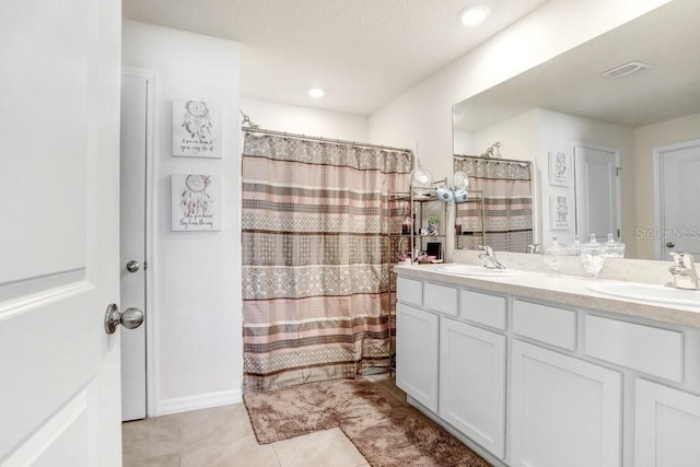 bathroom featuring walk in shower, vanity, and tile patterned floors