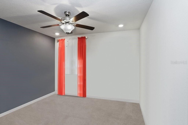 carpeted empty room featuring a textured ceiling and ceiling fan