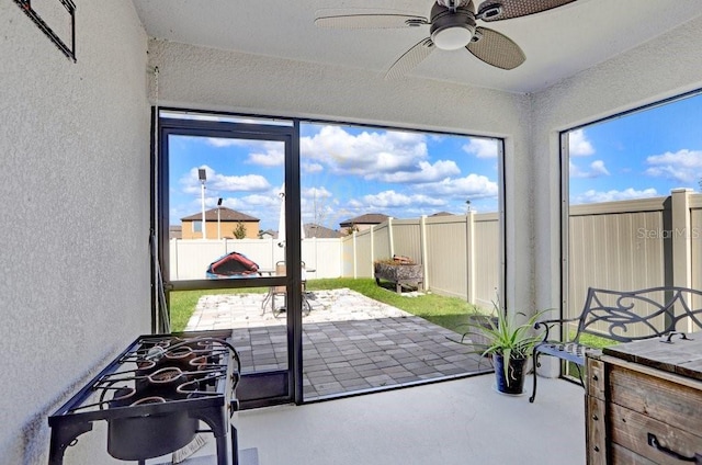 sunroom / solarium featuring a healthy amount of sunlight and ceiling fan