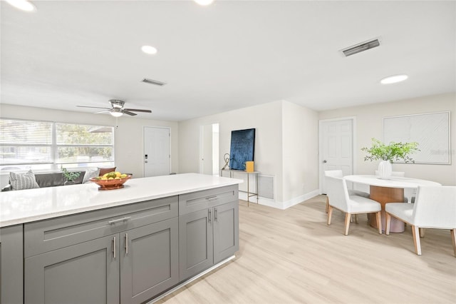 kitchen featuring ceiling fan, light hardwood / wood-style floors, and gray cabinets