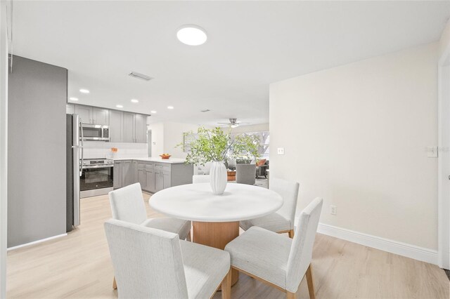 dining area with light wood-type flooring and ceiling fan