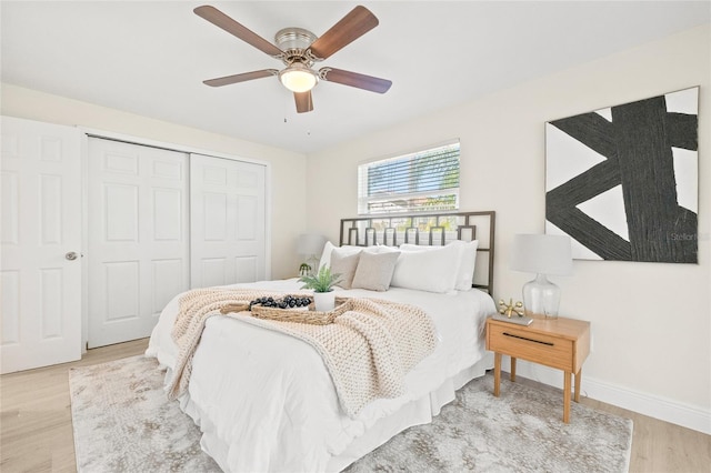 bedroom with a closet, light wood-type flooring, and ceiling fan