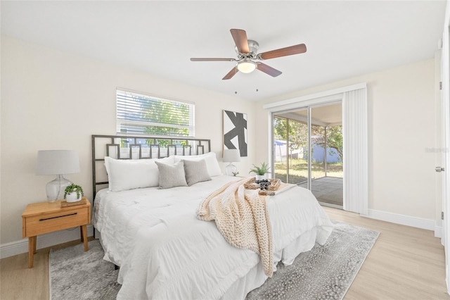 bedroom featuring access to exterior, multiple windows, light wood-type flooring, and ceiling fan