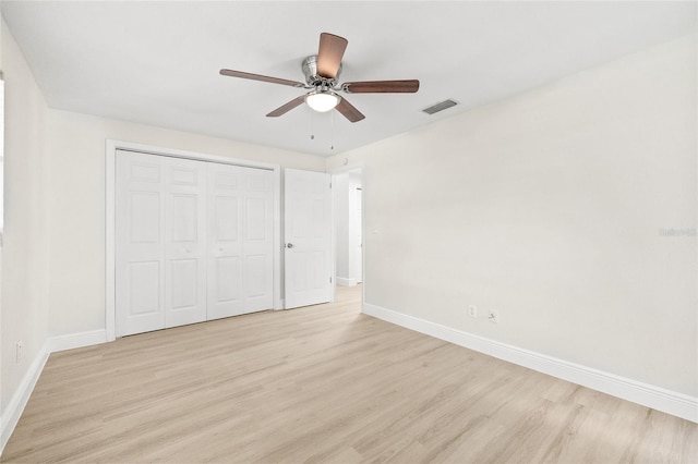 unfurnished bedroom featuring light hardwood / wood-style flooring, a closet, and ceiling fan