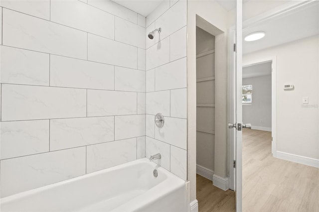 bathroom with tiled shower / bath combo and hardwood / wood-style flooring