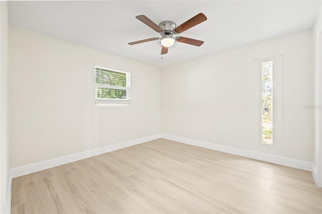 empty room with ceiling fan, light wood-type flooring, and a wealth of natural light