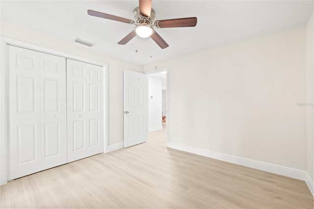 unfurnished bedroom with a closet, light hardwood / wood-style floors, and ceiling fan