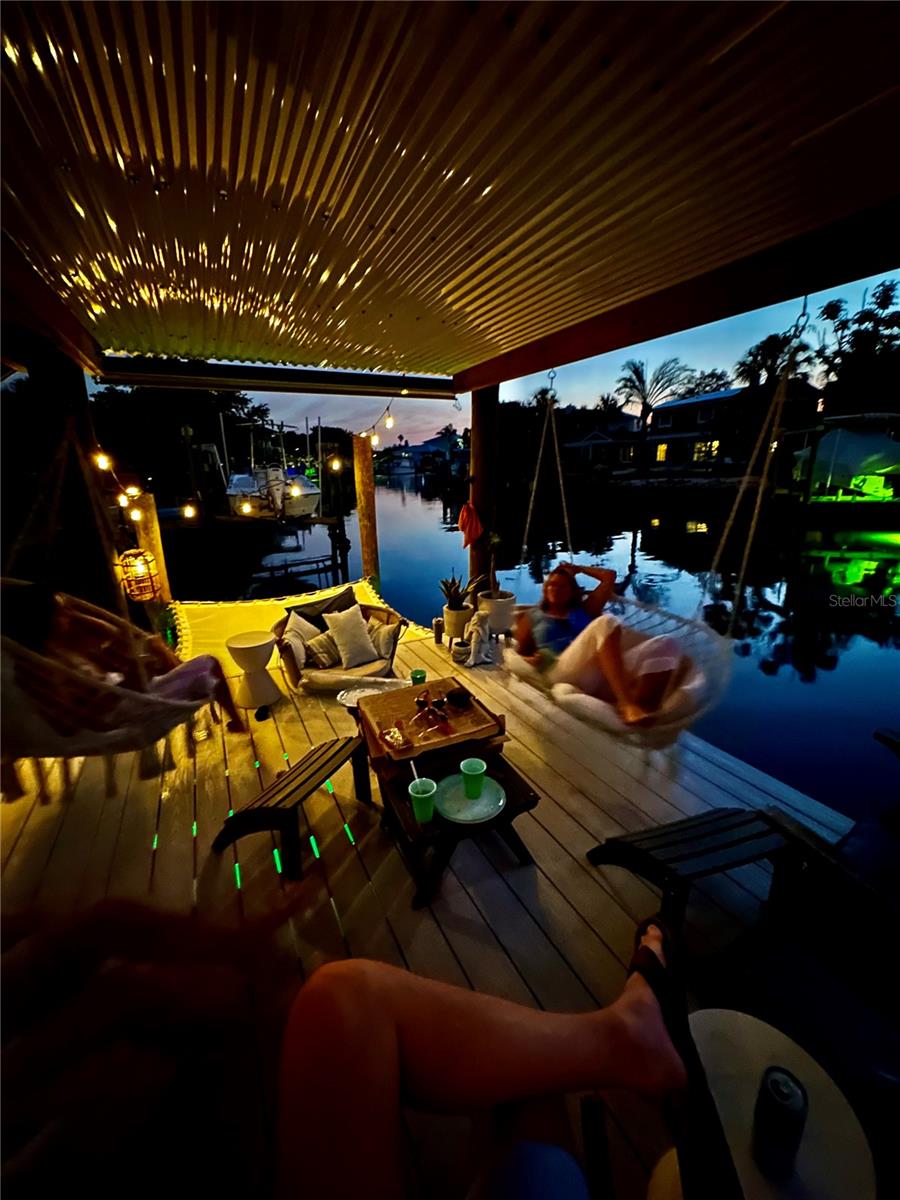 view of patio / terrace featuring an outdoor living space, a water view, and a boat dock