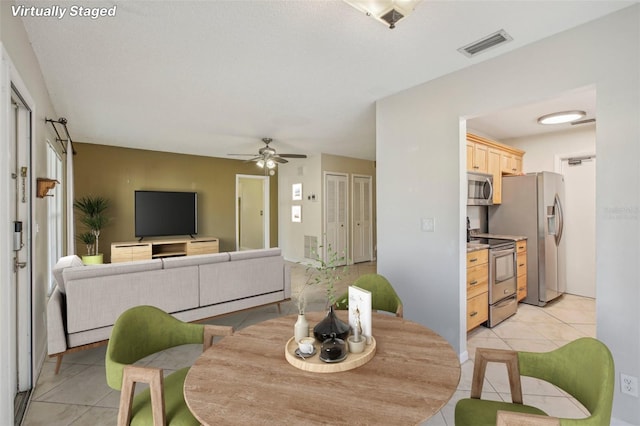 dining space featuring ceiling fan and light tile patterned flooring