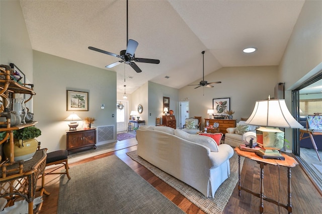 living room featuring hardwood / wood-style floors, a textured ceiling, vaulted ceiling, and ceiling fan