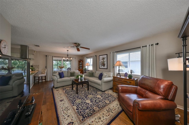 living room with ceiling fan, dark wood-type flooring, and a textured ceiling