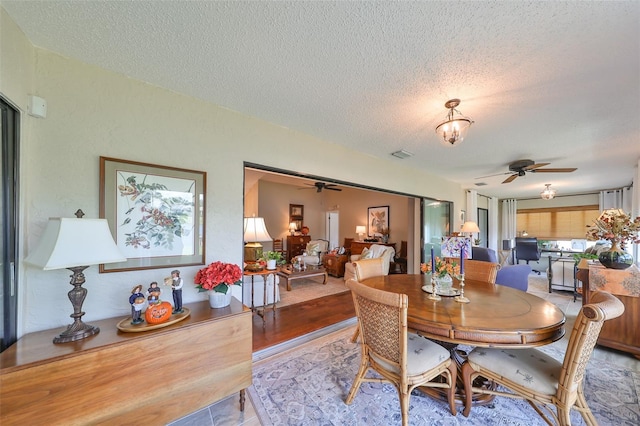 dining room with a textured ceiling and ceiling fan