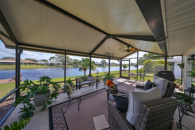 sunroom / solarium with ceiling fan, a water view, and vaulted ceiling